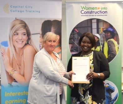 A graduate of the Women in Construction programme receives their completion certificate